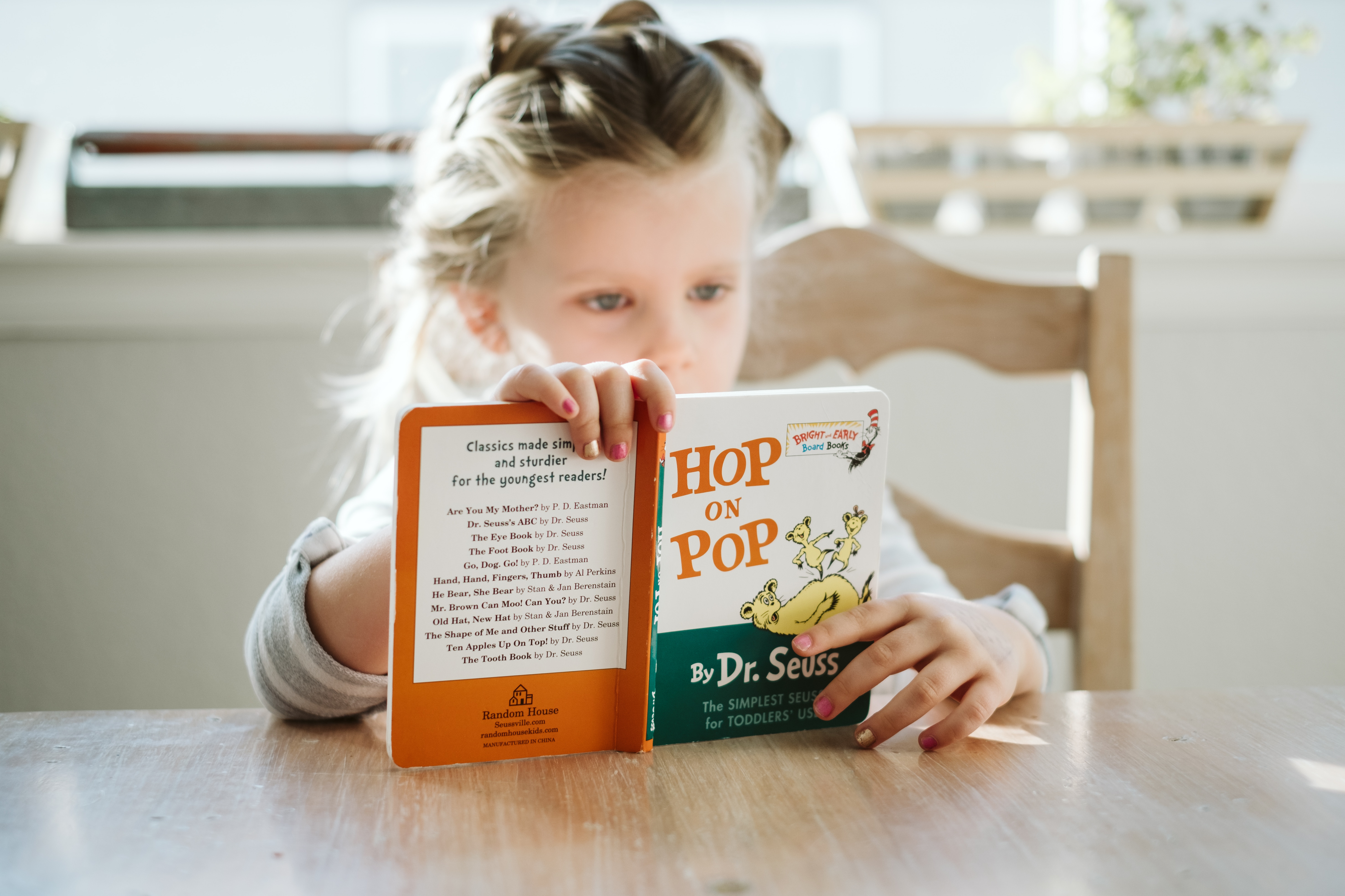 Petite fille lisant le livre Hop on Pop du Dr Seuss